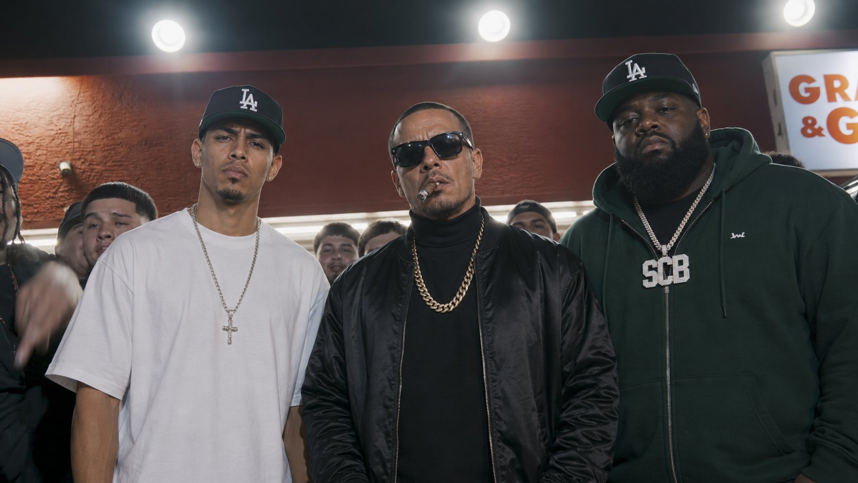 SoCalBoyz SCB — T-Breeze, The Maestro and KY outside a Los Angeles liquor store at night, crowd behind them.